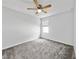 This bedroom has a ceiling fan, neutral gray carpet, and a window for natural light at 584 S Andrea Cir, Haines City, FL 33844