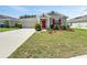 Inviting single-Gathering home with a well-kept lawn, red door, tidy shrubs, and an attached two-car garage at 584 S Andrea Cir, Haines City, FL 33844