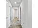 Hallway with wood-look flooring leads to a bathroom with a shower and rooms with neutral carpet at 584 S Andrea Cir, Haines City, FL 33844