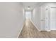 Long hallway with wood-look tile flooring, white walls, and doors leading to various rooms at 584 S Andrea Cir, Haines City, FL 33844