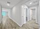 Hallway with wood-look tile floors, white walls, and doors leading to the bathroom and bedrooms at 584 S Andrea Cir, Haines City, FL 33844