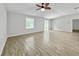 Spacious living room with wood tile flooring, ceiling fan, and natural light, creating a warm and inviting atmosphere at 584 S Andrea Cir, Haines City, FL 33844