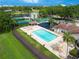 Aerial view of a community pool with a spa, lounging area, tennis court, and playground at 6019 Crystal View Dr, Orlando, FL 32819