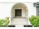 A grand arched entrance welcomes you to the home, framed by lush landscaping and a freshly tiled porch at 6019 Crystal View Dr, Orlando, FL 32819