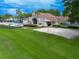 Community clubhouse exterior featuring a sand volleyball court, pool and well-manicured green lawn at 6019 Crystal View Dr, Orlando, FL 32819
