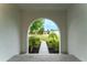 View of the front yard through an arched doorway, showcasing mature landscaping at 6019 Crystal View Dr, Orlando, FL 32819