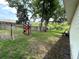 Fenced backyard featuring a wooden playset for , grass and several trees providing shade at 6230 Cranberry Dr, Port Orange, FL 32127