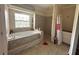 Luxurious bathroom featuring a soaking tub, a tiled shower, and ample natural light at 6230 Cranberry Dr, Port Orange, FL 32127