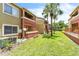Multi-story building with balconies surrounded by green grass, palm trees, and a fence at 664 Kenwick Cir # 104, Casselberry, FL 32707