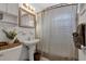 This bathroom includes a pedestal sink and tub with a striped shower curtain, blending functionality with a classic design at 6805 Barby Ln, Belle Isle, FL 32812