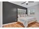 Modern bedroom featuring a dark accent wall and natural light from large windows at 6805 Barby Ln, Belle Isle, FL 32812