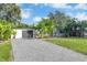 Beautiful home exterior featuring a well-maintained lawn, long driveway, and tasteful landscaping with tropical plants at 6805 Barby Ln, Belle Isle, FL 32812
