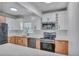 Updated kitchen featuring stainless steel appliances, including a range, microwave and dishwasher, and two-tone cabinets at 6805 Barby Ln, Belle Isle, FL 32812