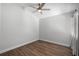 Empty bedroom features wood floors, a ceiling fan, and natural light from a window at 7742 Sugar Bend Dr # 7742, Orlando, FL 32819