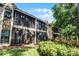 Rear exterior view of condos with screened lanais overlooking lush landscaping at 7742 Sugar Bend Dr # 7742, Orlando, FL 32819