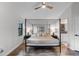 The bedroom features a four post bed frame and wood floors, with a view to the main bathroom at 7742 Sugar Bend Dr # 7742, Orlando, FL 32819