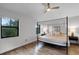 The bedroom features a four post bed frame and wood floors, with a view to the windows at 7742 Sugar Bend Dr # 7742, Orlando, FL 32819