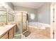 Bathroom features a tub, glass shower, vanity and tile floors at 7924 Bridgestone Dr, Orlando, FL 32835