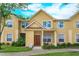 Charming two-story townhome with yellow siding, a well-manicured lawn, and a welcoming front porch area at 835 Grand Regency Pt # 104, Altamonte Springs, FL 32714