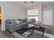 Cozy living room featuring a plush gray sectional sofa, modern rug, and bright natural light from a large window at 835 Grand Regency Pt # 104, Altamonte Springs, FL 32714