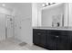 Well lit bathroom featuring a double vanity with a granite countertop, cabinets, and a glass enclosed shower at 9591 Amber Chestnut Way, Winter Garden, FL 34787