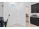 Clean entryway with a white door, black cabinets, and granite countertop, showcasing the home's modern design at 9591 Amber Chestnut Way, Winter Garden, FL 34787