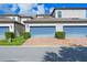Charming two-story townhome with blue garage doors, brick driveway, and well-maintained landscaping at 9591 Amber Chestnut Way, Winter Garden, FL 34787