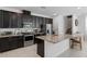 Modern kitchen with stainless steel appliances, granite countertops, and dark cabinetry, offering a sleek design at 9591 Amber Chestnut Way, Winter Garden, FL 34787