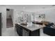 Granite kitchen island featuring a sink and stainless steel dishwasher, connecting the kitchen to the dining and living areas at 9591 Amber Chestnut Way, Winter Garden, FL 34787