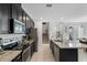 Well-equipped kitchen with stainless steel appliances, granite countertops, and seamless flow to the staircase at 9591 Amber Chestnut Way, Winter Garden, FL 34787