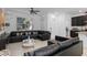 Stylish living room featuring a large sectional sofa, ceiling fan, and granite countertop at 9591 Amber Chestnut Way, Winter Garden, FL 34787