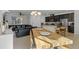 Open-concept living area featuring a wooden dining table, leather sofa, and modern kitchen with stainless steel appliances at 9591 Amber Chestnut Way, Winter Garden, FL 34787