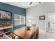 Charming dining area with blue accent wall, wooden table, and view of the backyard at 10064 River Glen Ct, Orlando, FL 32825