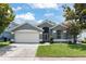 Charming single-story home with a two-car garage, neutral paint, and well-manicured lawn at 10064 River Glen Ct, Orlando, FL 32825