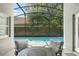 Screened-in pool with comfortable seating and lush backyard landscaping creating a private oasis at 10064 River Glen Ct, Orlando, FL 32825