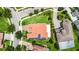 Aerial view showcasing a home's red tile roof, solar panels, and landscaped yard at 10630 Mobberley Cir, Orlando, FL 32832