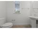 A neutral powder room offers a pedestal sink, toilet, and natural light from a window at 10630 Mobberley Cir, Orlando, FL 32832