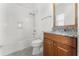 Bathroom featuring white tiled shower-tub and granite countertop vanity with a wood cabinet at 10630 Mobberley Cir, Orlando, FL 32832