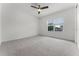 Bedroom with neutral carpet, ceiling fan, window, and white paint at 10630 Mobberley Cir, Orlando, FL 32832