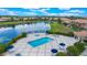 Aerial view of a community pool featuring comfortable seating, a hot tub, and shaded umbrellas by the water at 10630 Mobberley Cir, Orlando, FL 32832