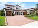 Elegant two-story home with a beautiful brick driveway and well-maintained landscaping at 10630 Mobberley Cir, Orlando, FL 32832