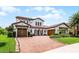 Exterior elevation of a luxurious two story home featuring a three car garage and manicured landscaping at 10630 Mobberley Cir, Orlando, FL 32832