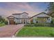 Beautiful two story home with a three-car garage, brick driveway, manicured lawn and lush landscaping at 10630 Mobberley Cir, Orlando, FL 32832