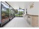 Covered outdoor kitchen with stainless grill, granite counters, sink, and tile floors overlooking yard at 10630 Mobberley Cir, Orlando, FL 32832