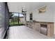 Enclosed outdoor kitchen with stainless steel grill, granite countertops, and tile flooring at 10630 Mobberley Cir, Orlando, FL 32832