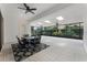 Bright sunroom featuring large windows, tile flooring, ceiling fans, and a dining set at 10630 Mobberley Cir, Orlando, FL 32832