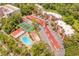 Aerial view showcases the community's layout, featuring a pool, tennis courts, parking, and well-maintained buildings nestled among trees at 1166 Carmel Cir # 120, Casselberry, FL 32707