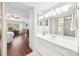 Bathroom with a white vanity, large mirror, and an adjacent bedroom with hardwood floors at 1166 Carmel Cir # 120, Casselberry, FL 32707