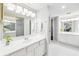 Bright bathroom featuring dual vanities, a large mirror, and modern lighting fixtures at 1166 Carmel Cir # 120, Casselberry, FL 32707