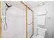 Bright bathroom featuring a white tiled shower with gold trim and updated fixtures at 1166 Carmel Cir # 120, Casselberry, FL 32707